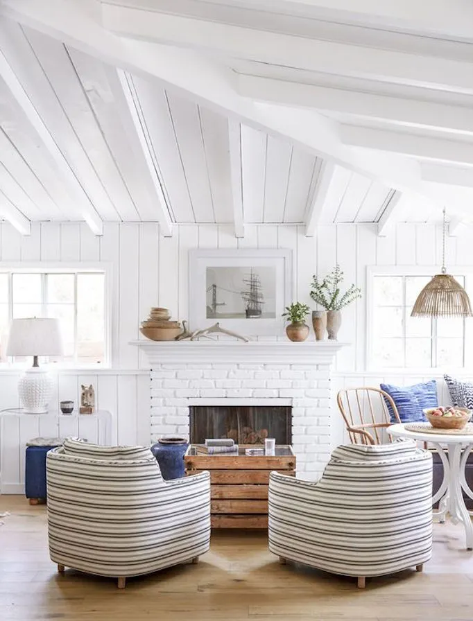 coastal living room with repurposed items for a vintage look. Vintage terra cotta pots, sea boat artwork.