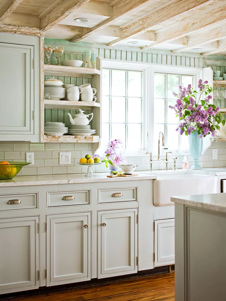 green kitchen cabinets, rustic wood beam ceiling and floating shelves, white farmhouse apron sink