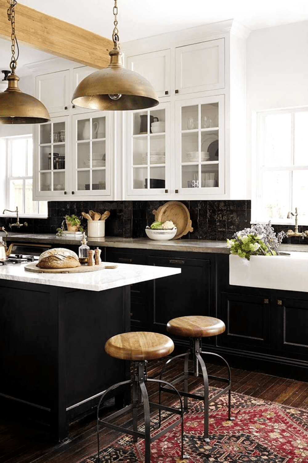 black kitchen cabinets, round industrial barstools with metal base, white farmhouse sink, gold dome pendant lights.