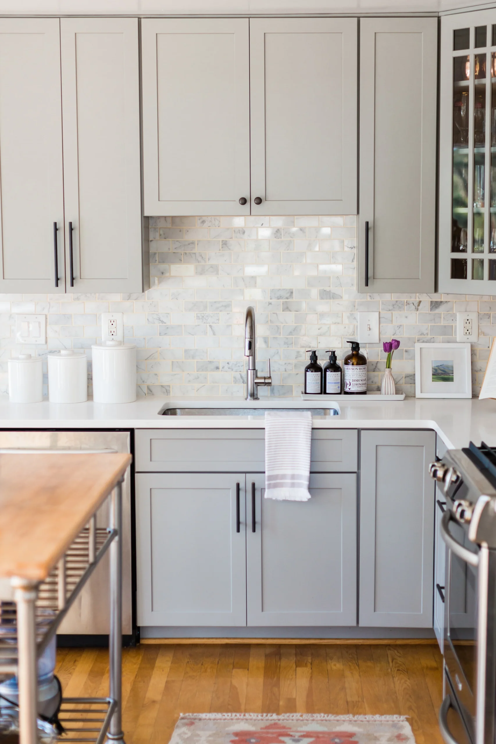 gray kitchen cabinets with matte black cabinet hardware and polished nickle faucet