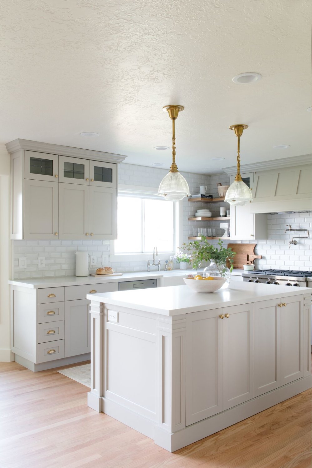 Light gray kitchen cabinet color with gold cabinet hardware and white quartz countertops