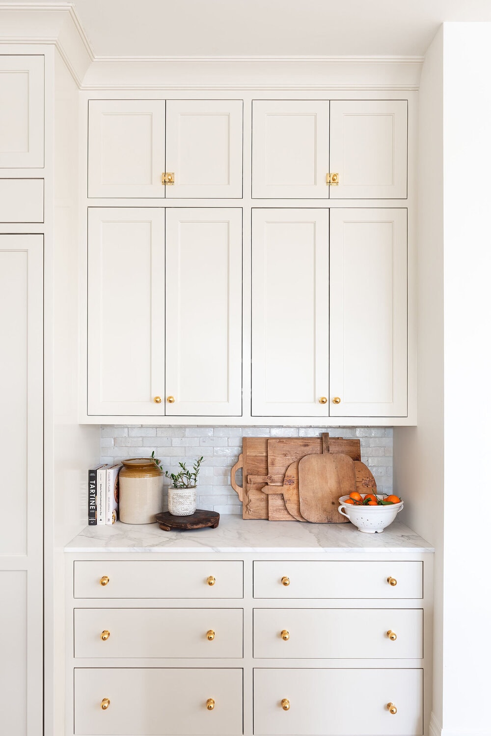 Light cream colored kitchen cabinets with gold hardware