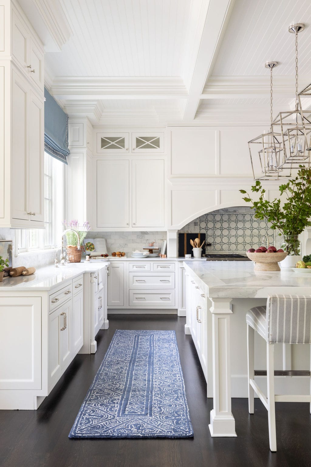 White kitchen cabinetry with blue and white home decor accents in window treatments, runner and barstools