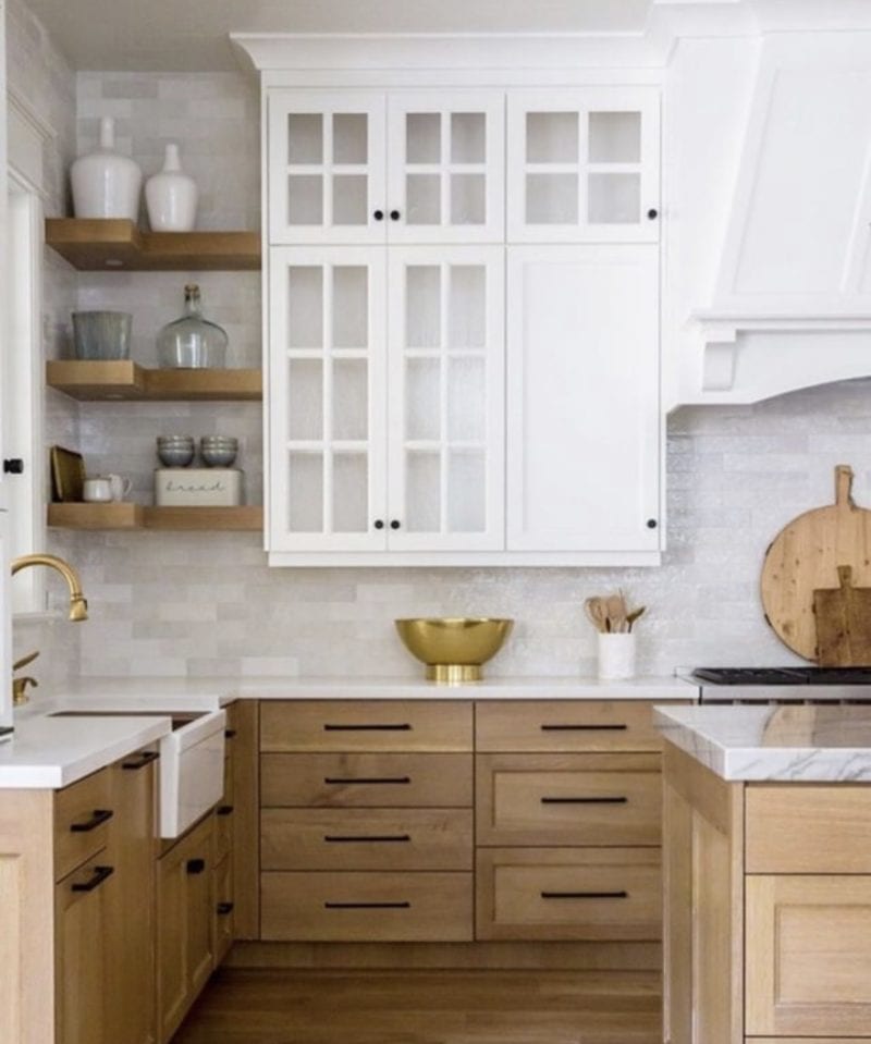 natural wood cabinet base with white upper cabinets and white subway tile, black cabinet hardware