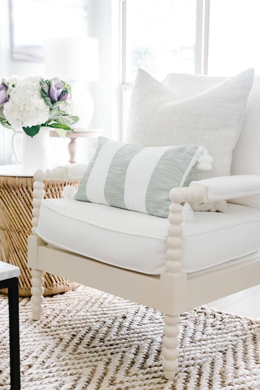 cream linen pillow paired with a green and white pillow on a side chair