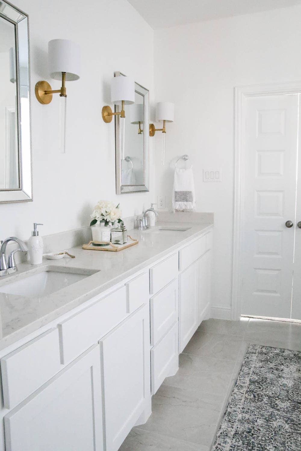 An all white bathroom shows clean and modern look with a few simple decor pieces.