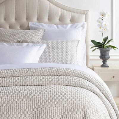 cream coverlet with white bedding.