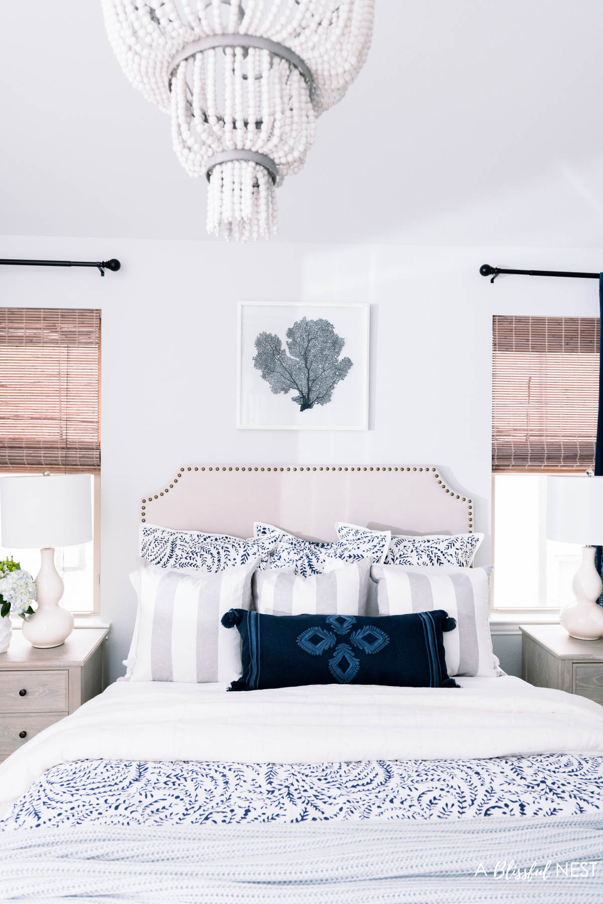 navy and white bedding layered with light blue and navy accents like throw pillows and blankets.