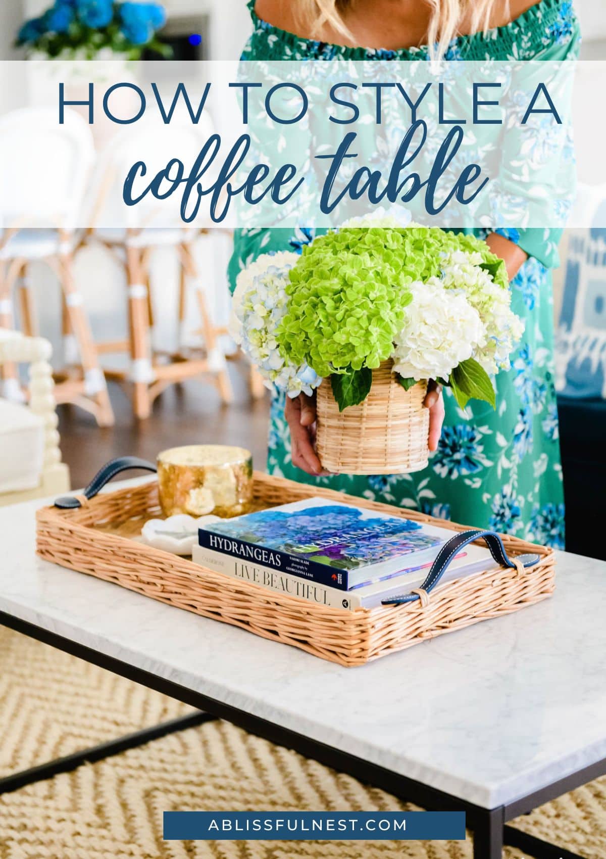 coffee table decor includes a rattan tray, rattan vase, lime green hydrangeas, coffee table books. 