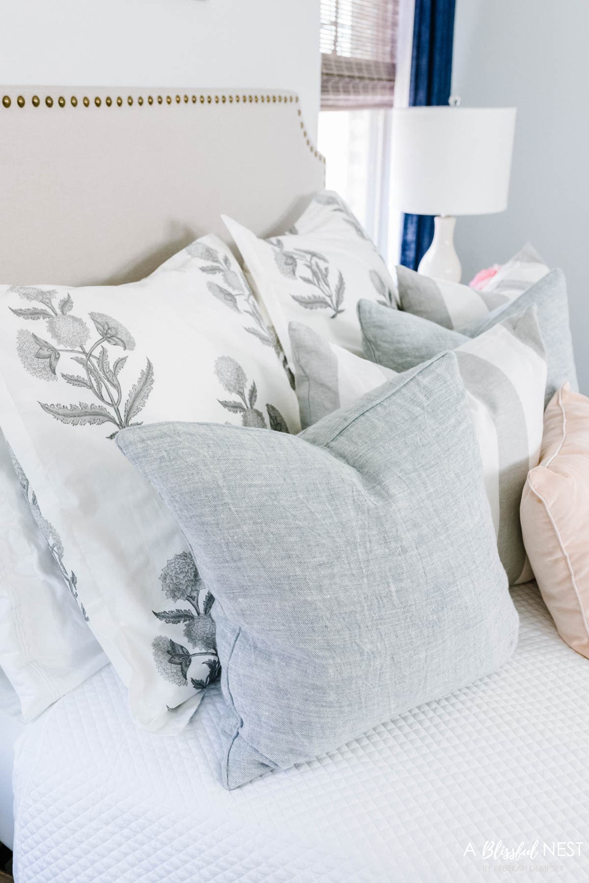 textured light blue pillow on bed for a little pop of color.