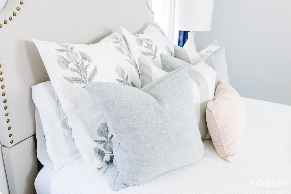 light blue accent pillows mixed with grey and white flower bedding