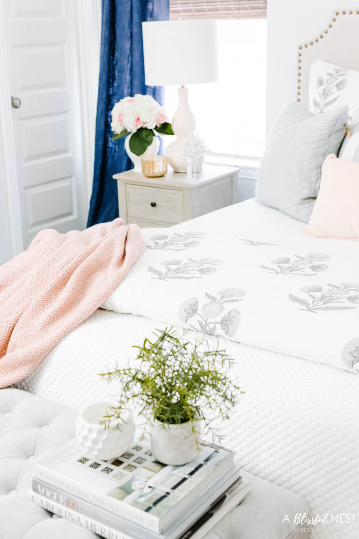 lightweight throw blanket in a soft blush pink at the end of the bed