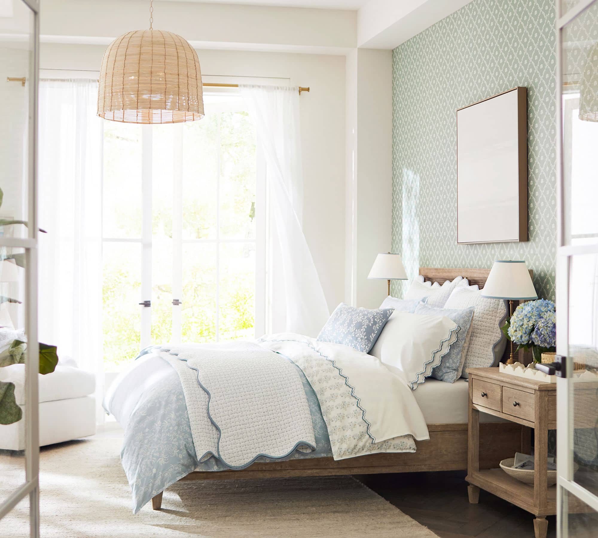 white coverlet with scalloped edge detail in blue paired with soft blue and white bedding