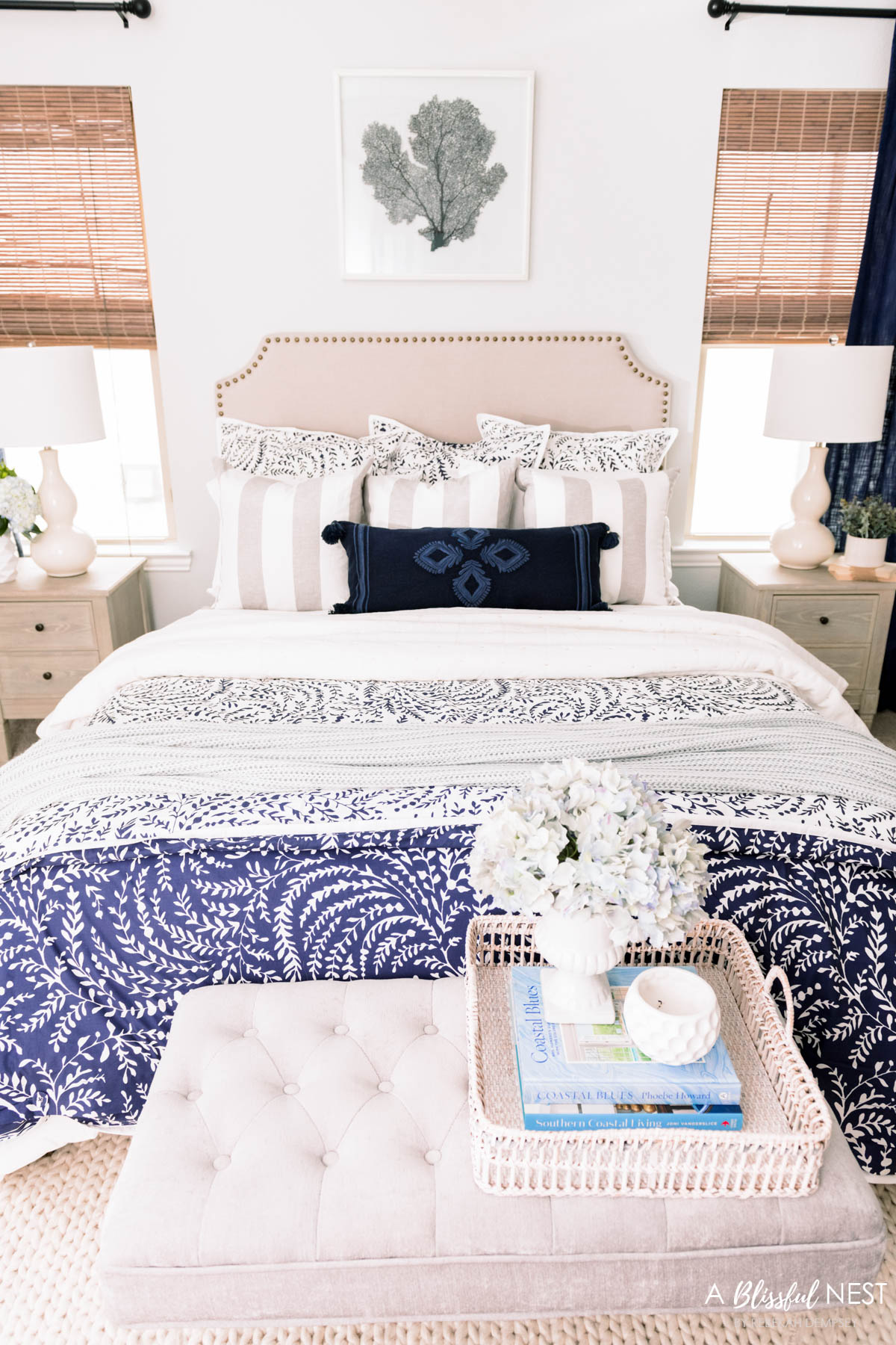 a beautiful blue and white bedroom with cream and white accents.