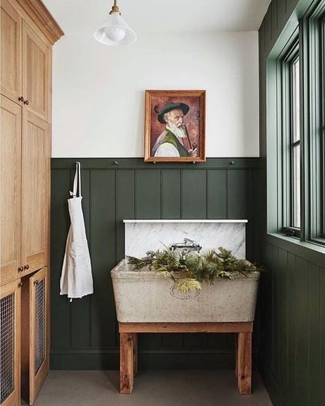 forest green board and batten in a laundry room with a wash sink
