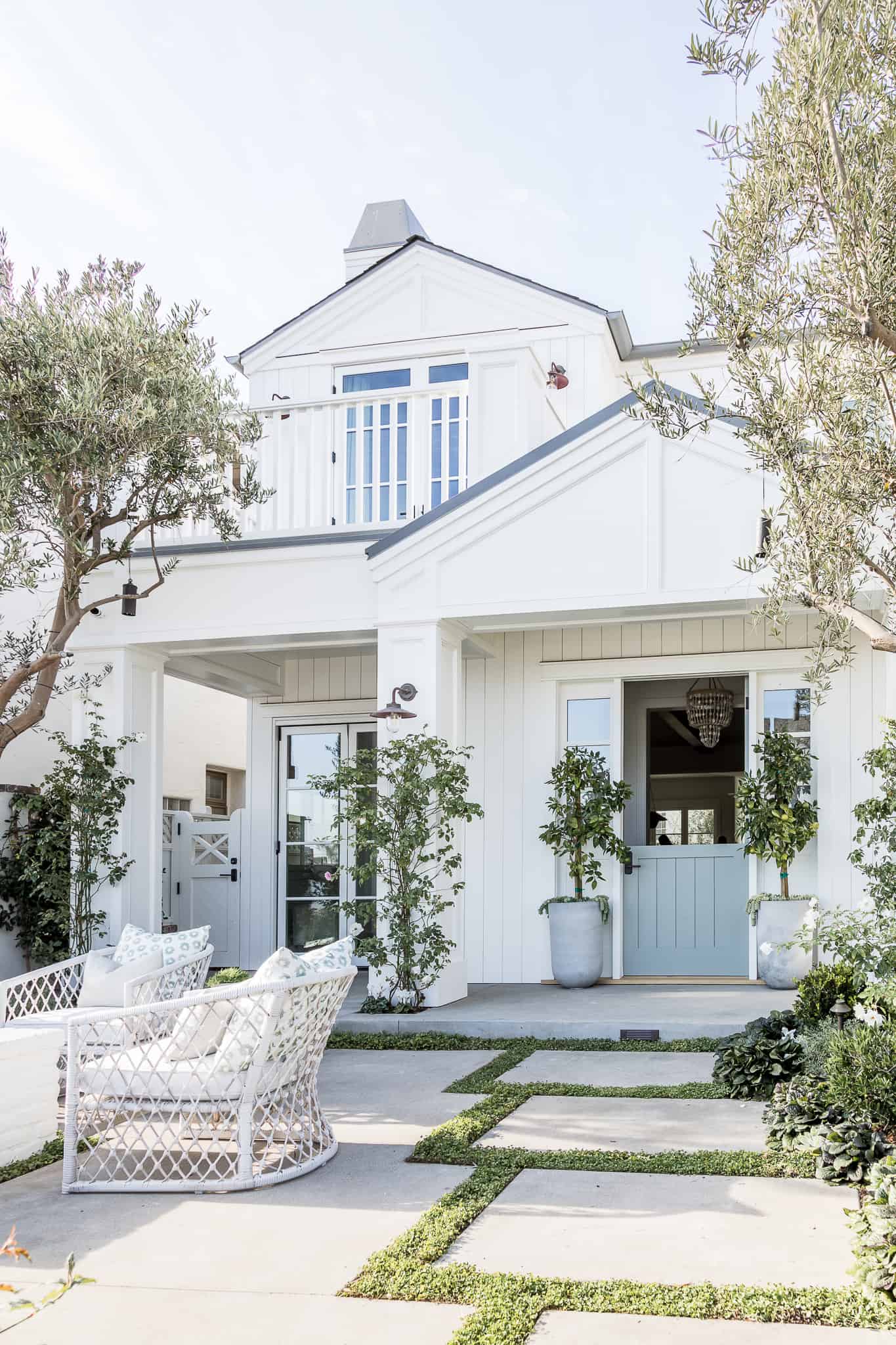 white painted house with light blue door and farmhouse lights. 