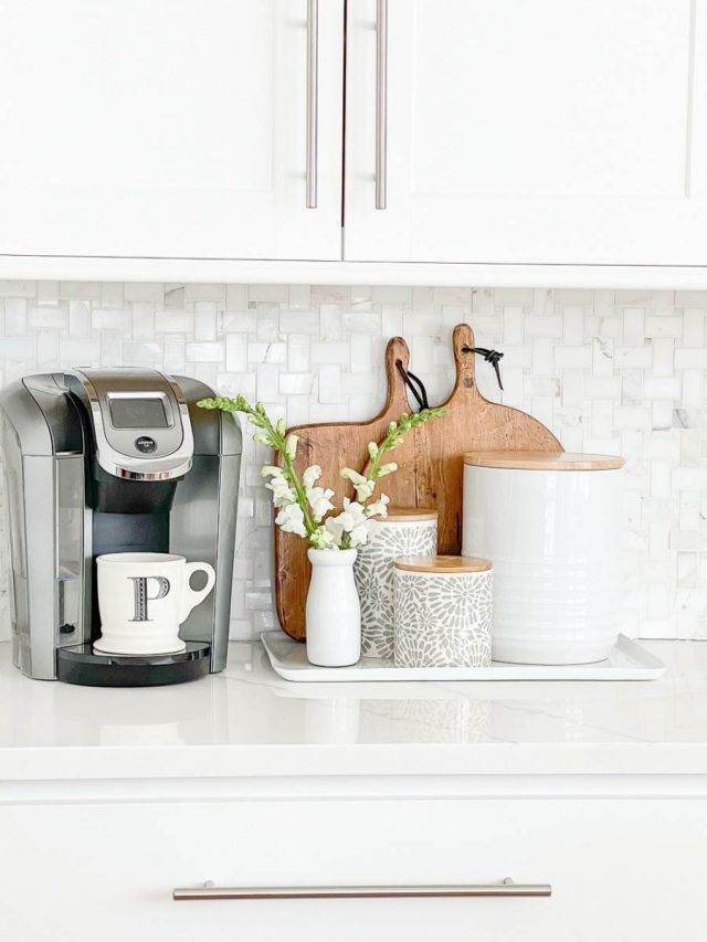 coffee bar with a keurig machine, wood cutting boards and white canisters.