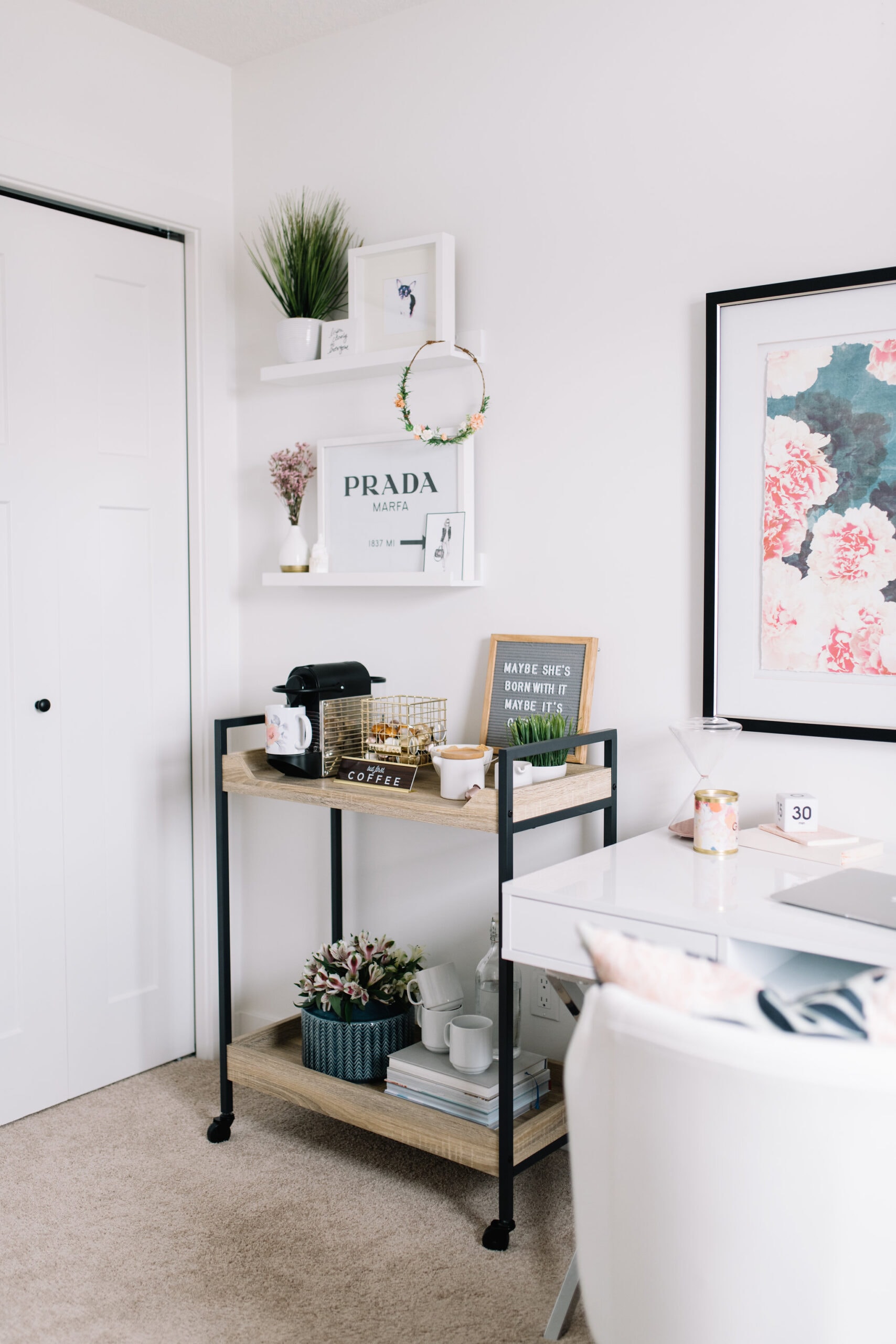 a bar cart is used in the corner of a home office for a coffee station