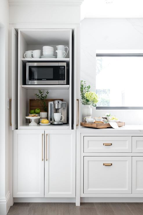 a dedicated cabinet in a kitchen for a coffee station. Includes closed doors to hide appliances and coffee accessories.