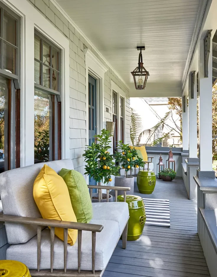 Yellow and green pillows and garden stools on a front porch