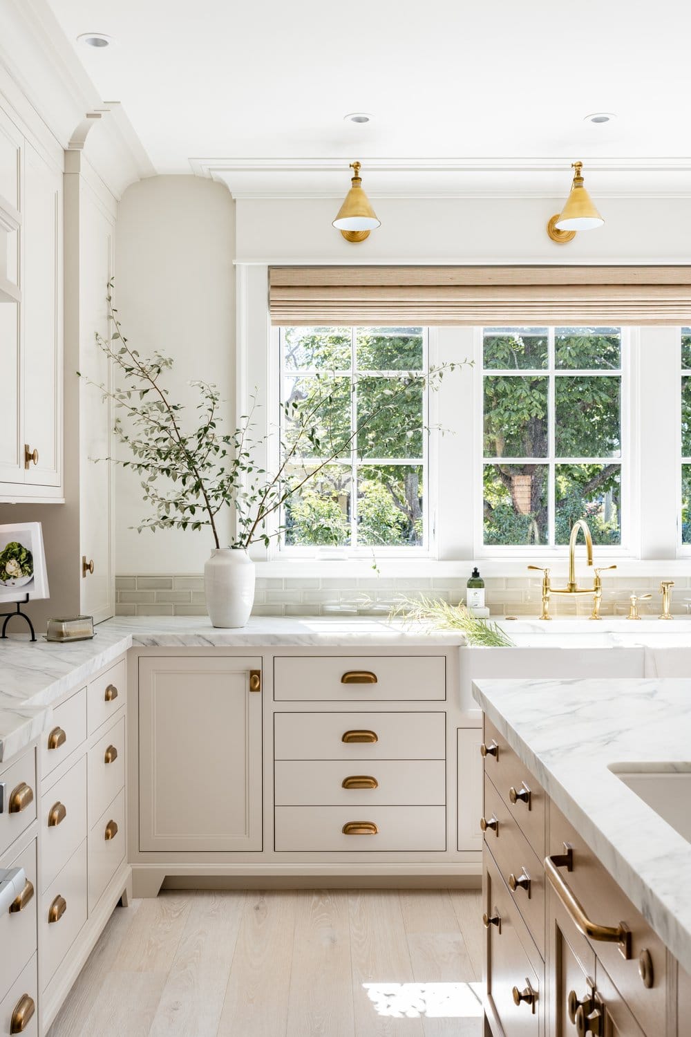 white kitchen with marble countertops and gold hardware