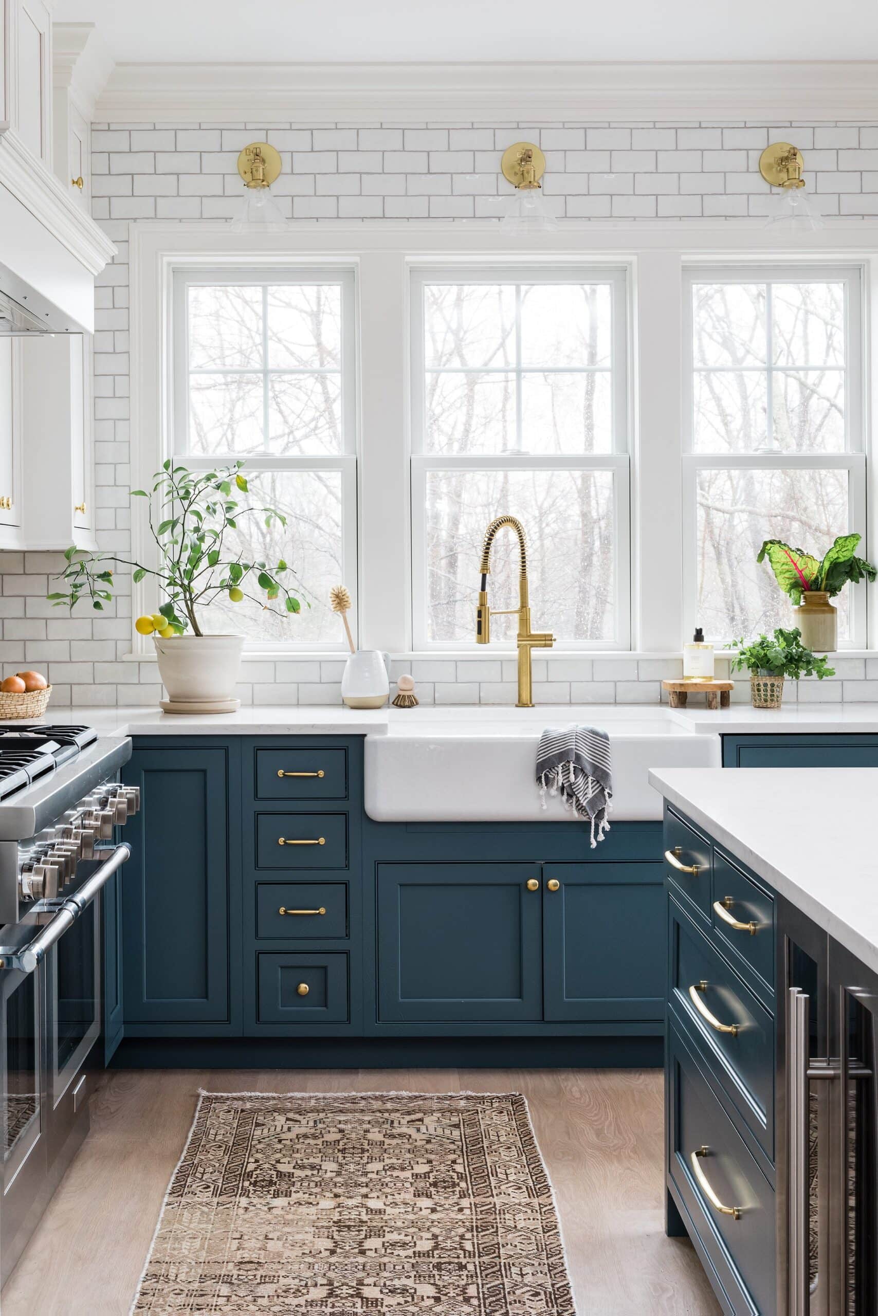 navy blue kitchen cabinets with a white farmhouse sink