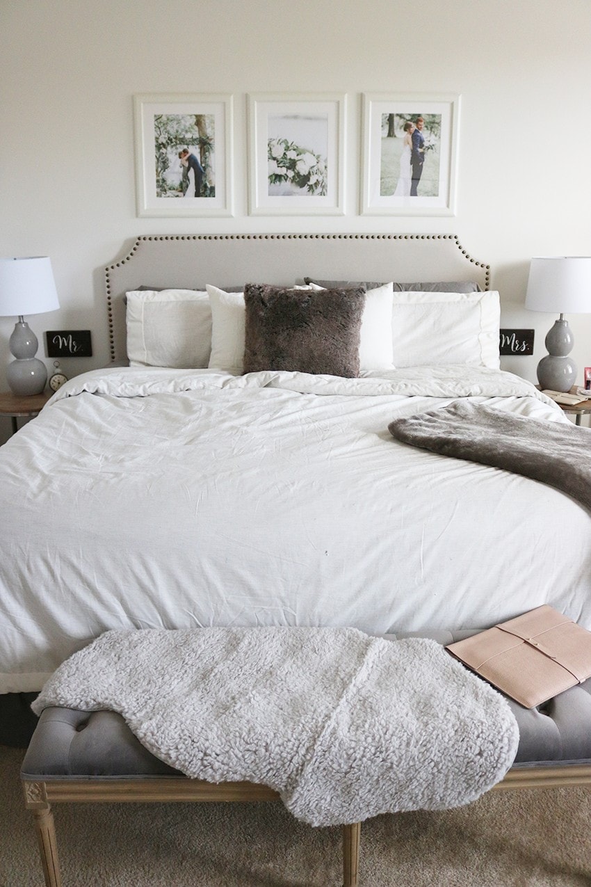 3 white frames with wedding photos above an upholstered bed