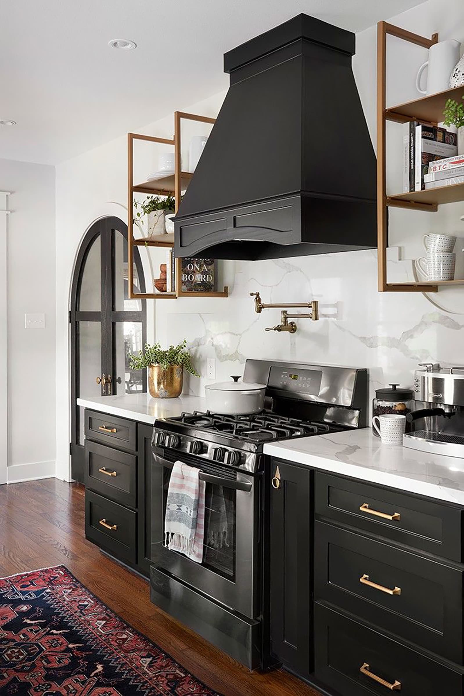 Black kitchen cabinets with gold hardware and white quartz counters