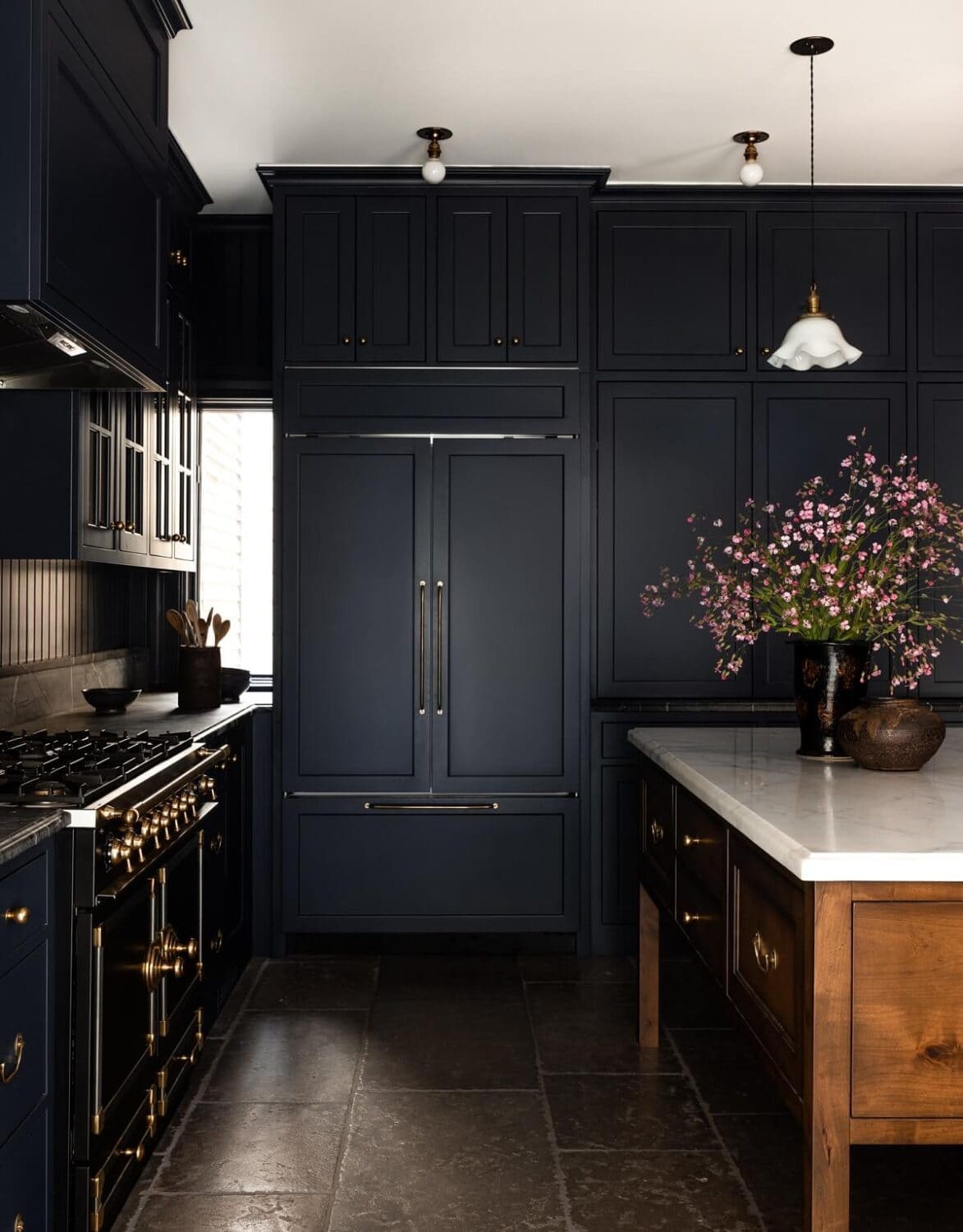 dark navy kitchen cabinets with a cherry wood kitchen island