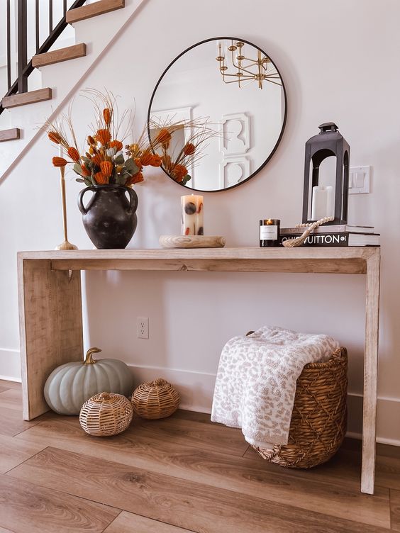 simple wood console table with pumpkins and a black lantern