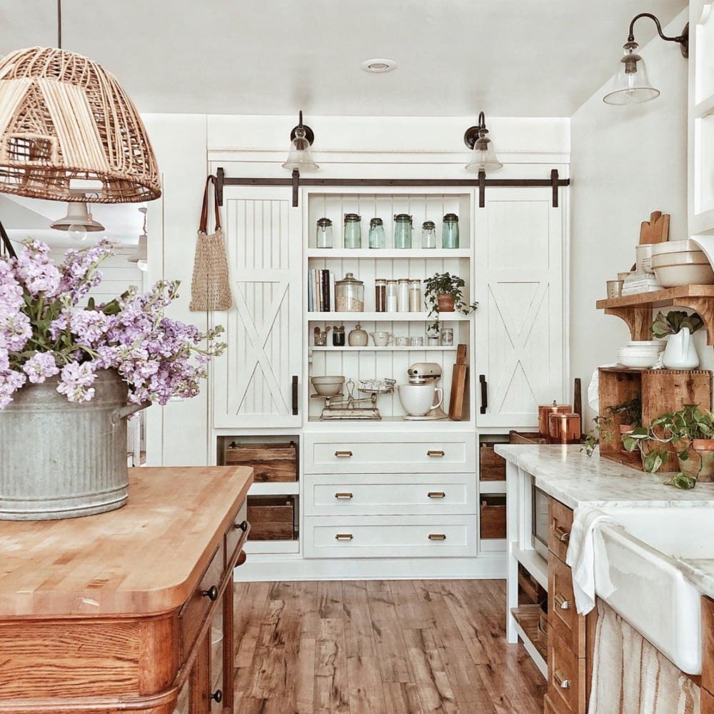 a cabinet holds vintage canisters and has sliding doors on a track