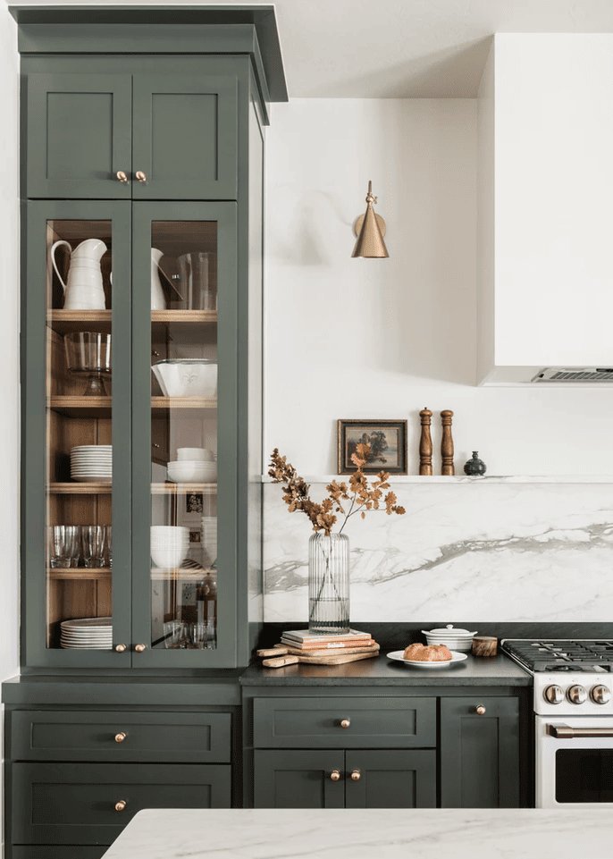 dark sage green kitchen cabinets with black countertops