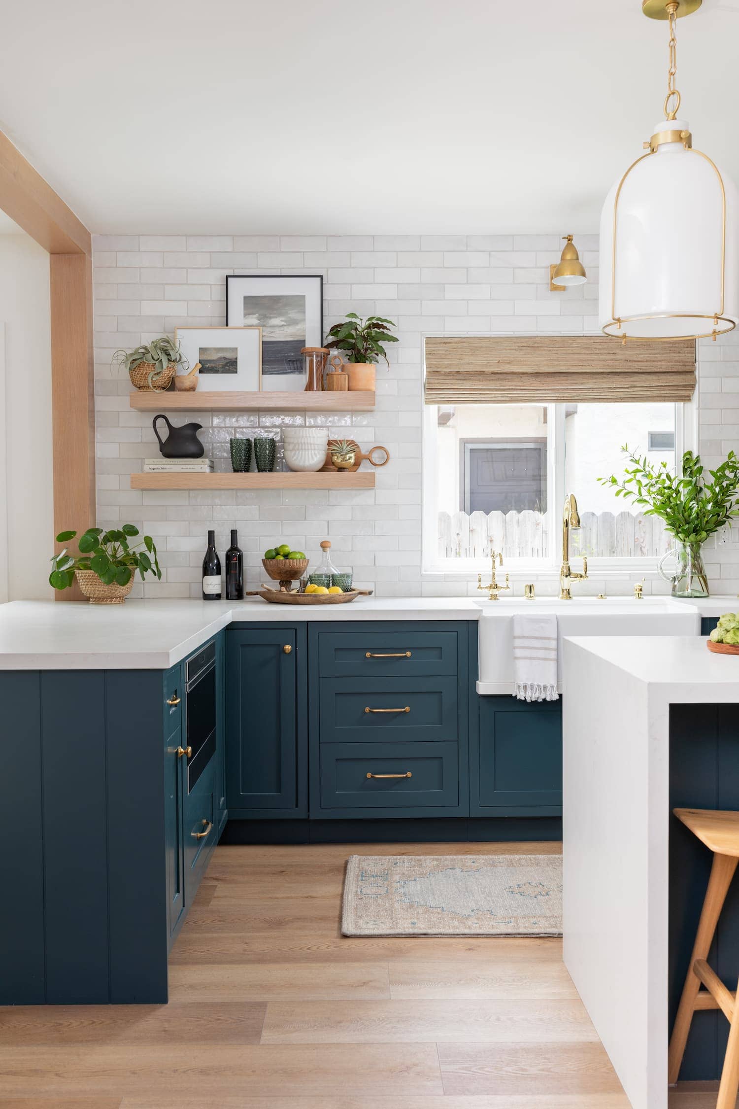 deep navy blue cabinets with white countertops and gold cabinet hardware