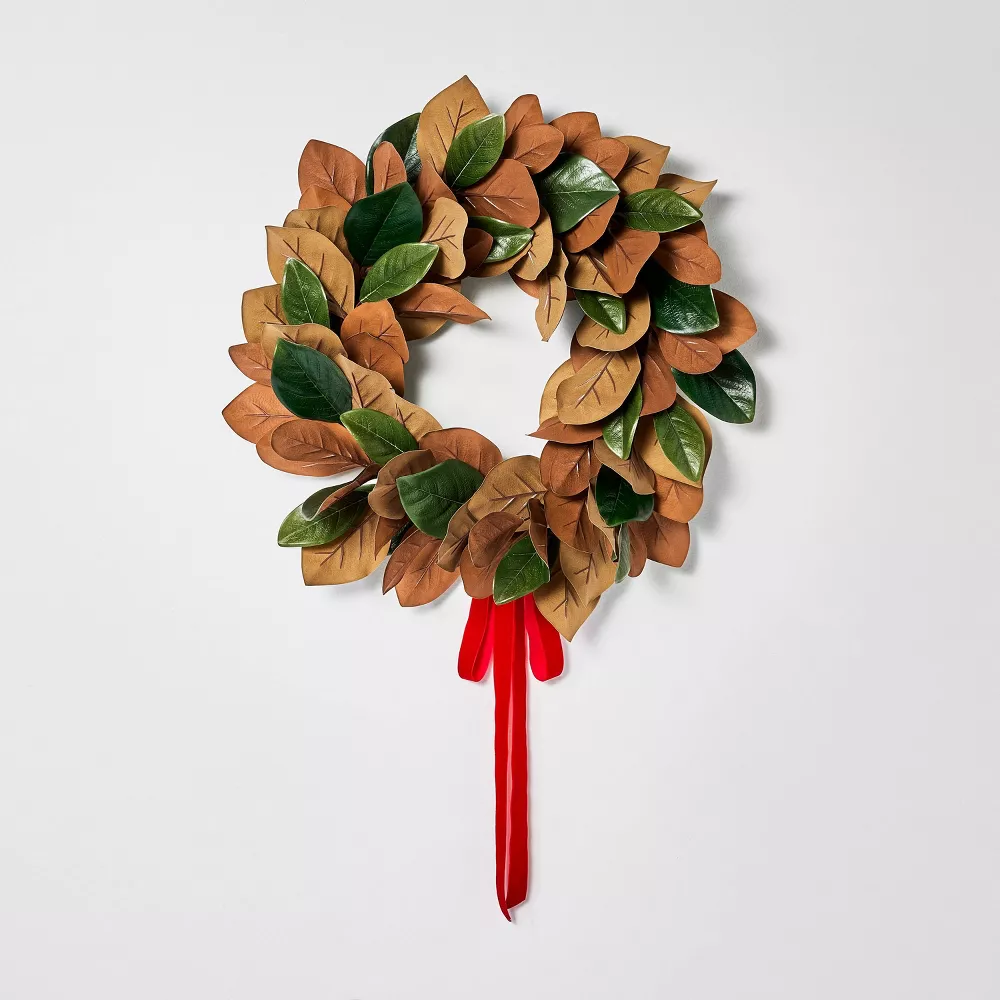 This green and gold magnolia leaf wreath has the prettiest red ribbon and is the perfect Christmas wreath to add in your home this season! #ABlissfulNest
