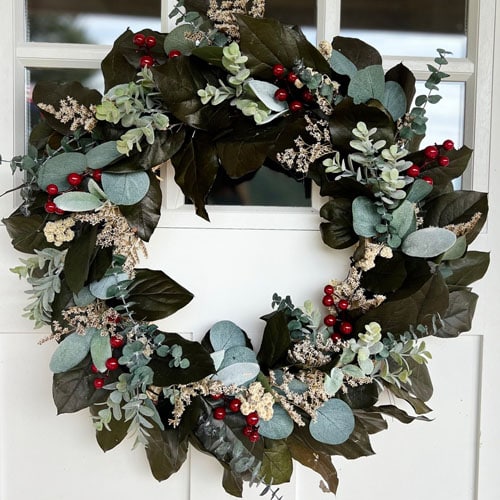 This lemon leaf wreath has the prettiest red berries and a mix of greenery! It's the prettiest holiday wreath for your front door! #ABlissfulNest