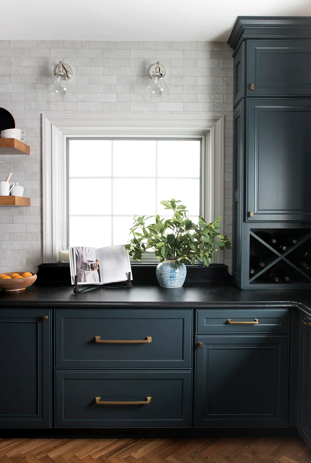 dark teal kitchen cabinets with black countertops.