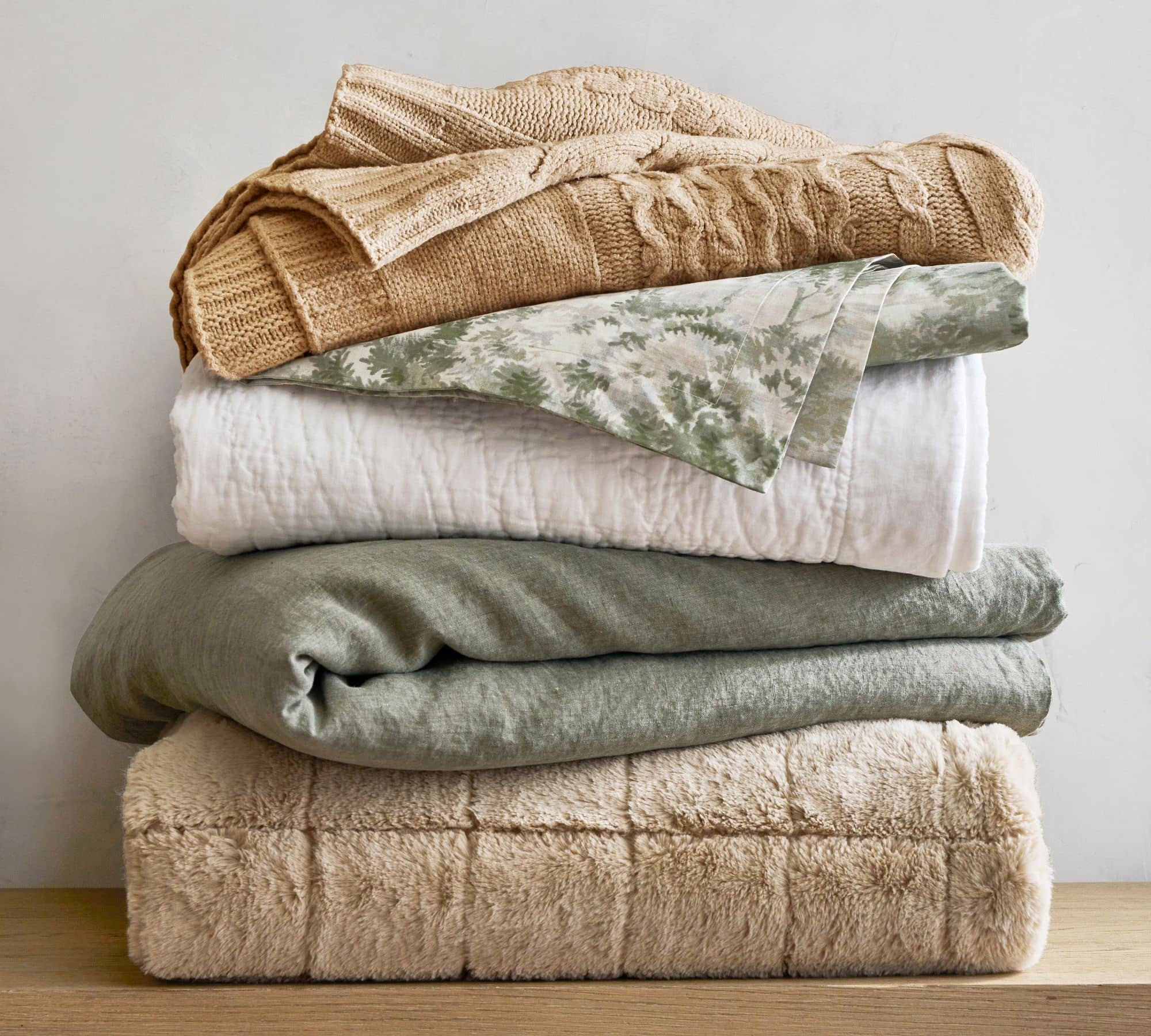 stack of cozy blankets to add to a bed
