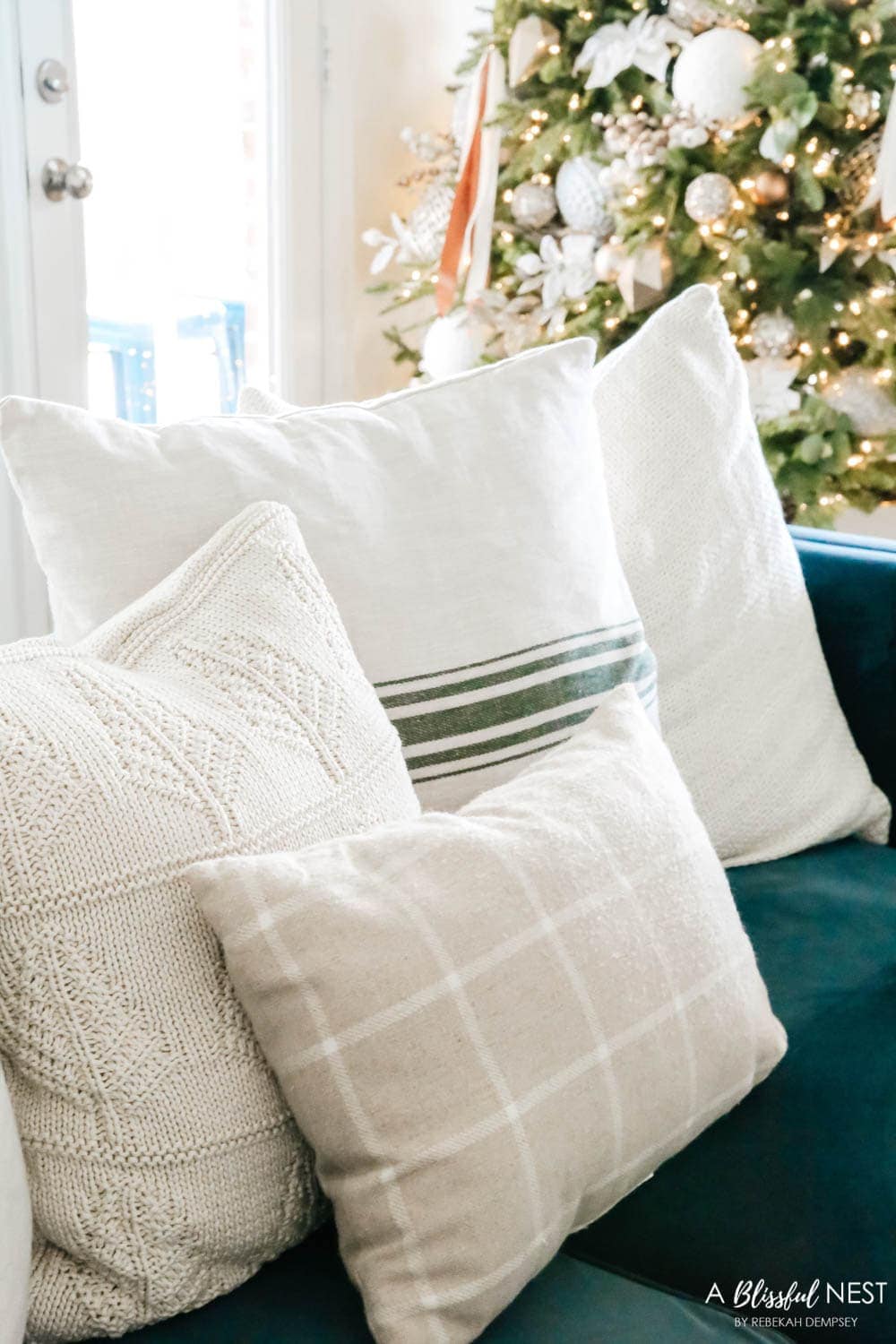 various cozy pillows in neutrals on a navy blue sofa