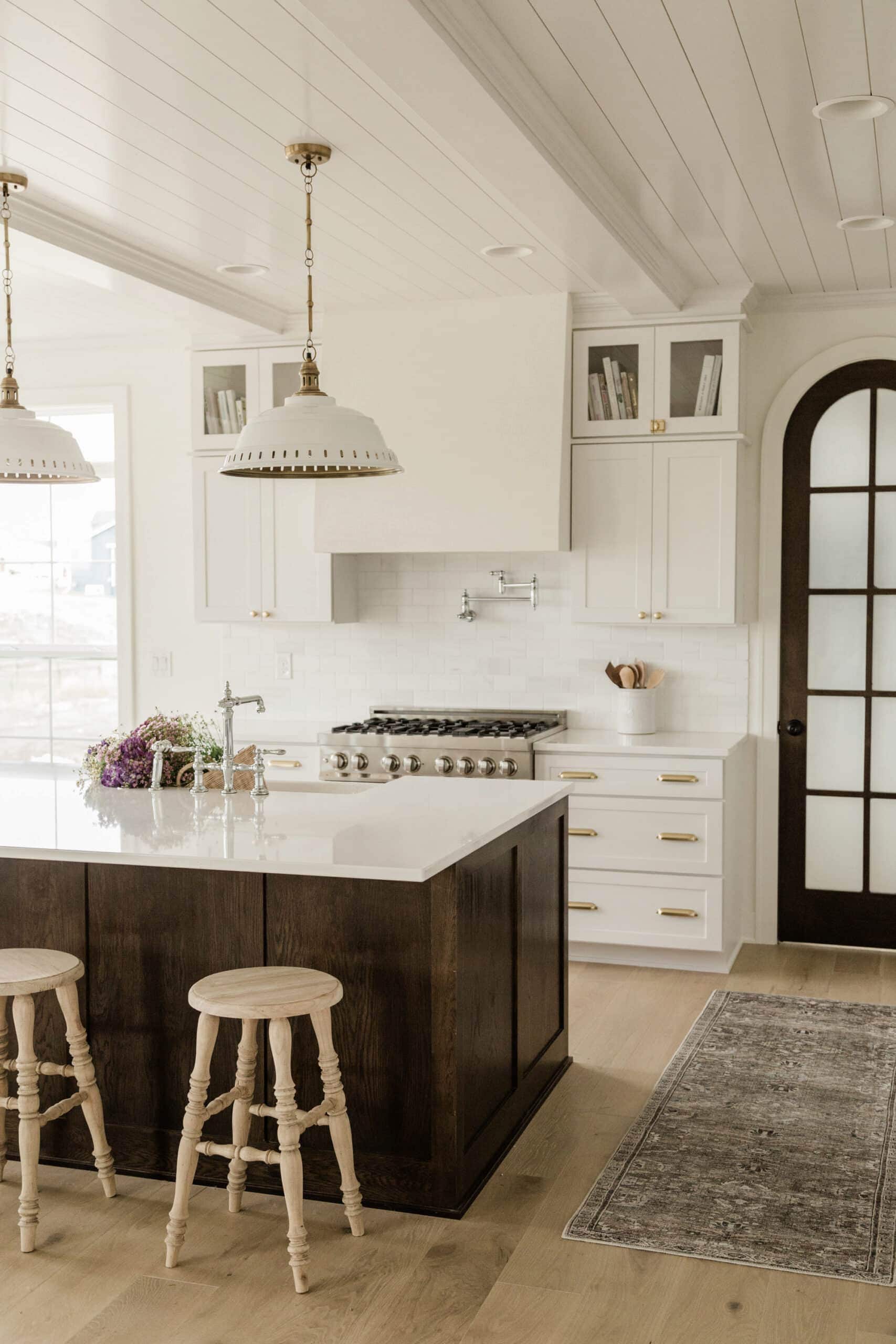 dark wood kitchen island and white cabinets with gold hardware