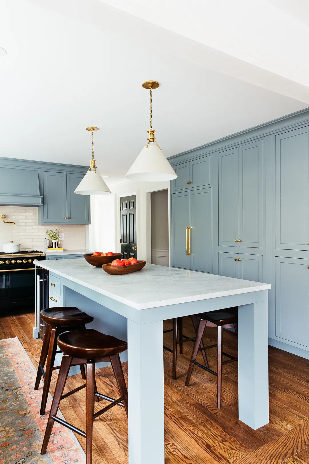 deep blue green kitchen cabinets with marble countertops, gold cabinet hardware, oak flooring