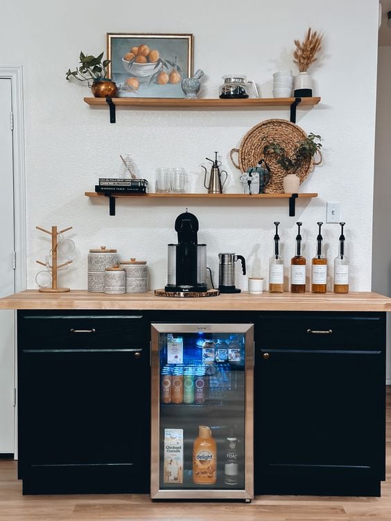 dark cabinets with a butch countertop and floating shelves to help organize this coffee station