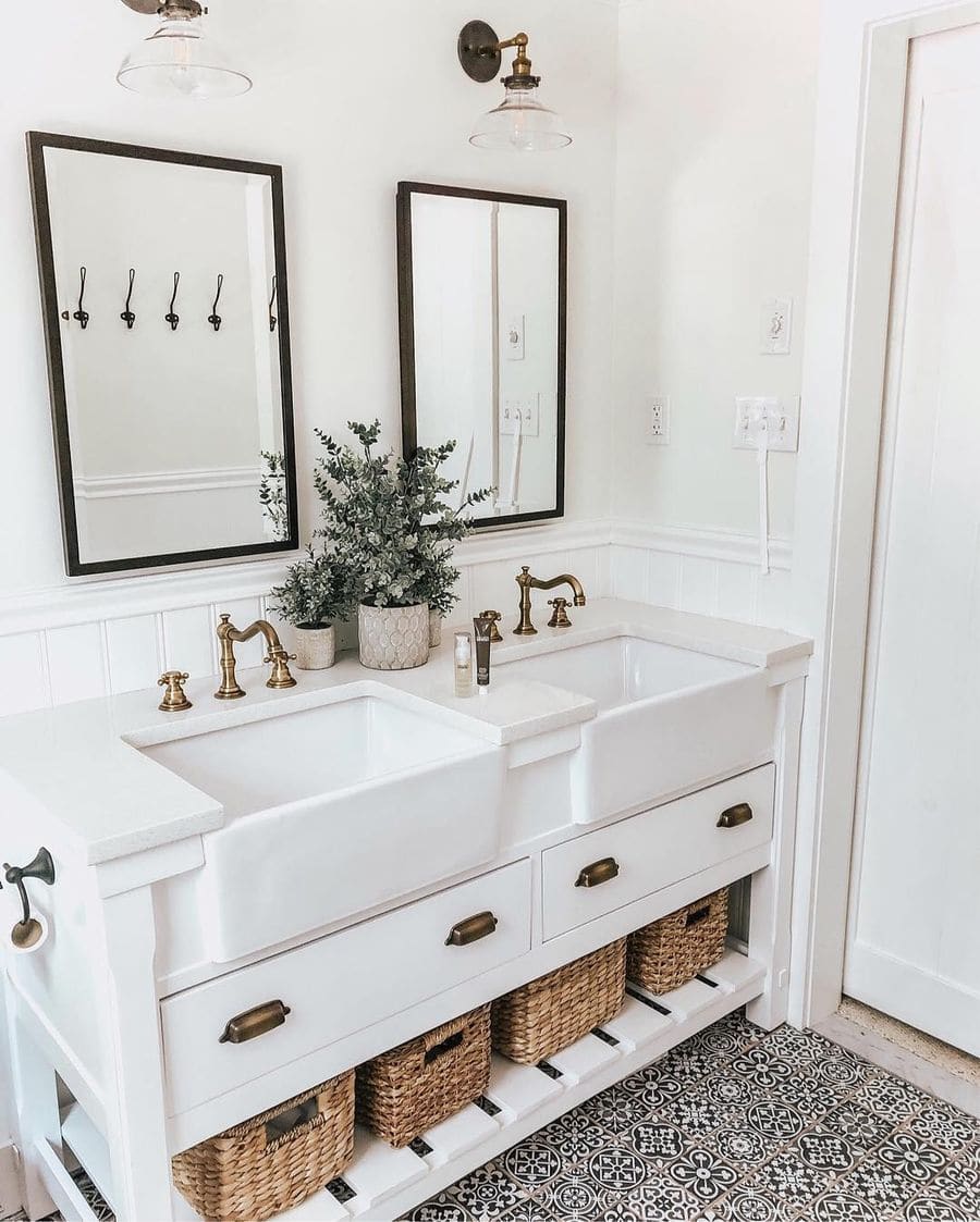 traditional farmhouse bathroom with white cabinets, farmhouse style sinks, and gold hardware