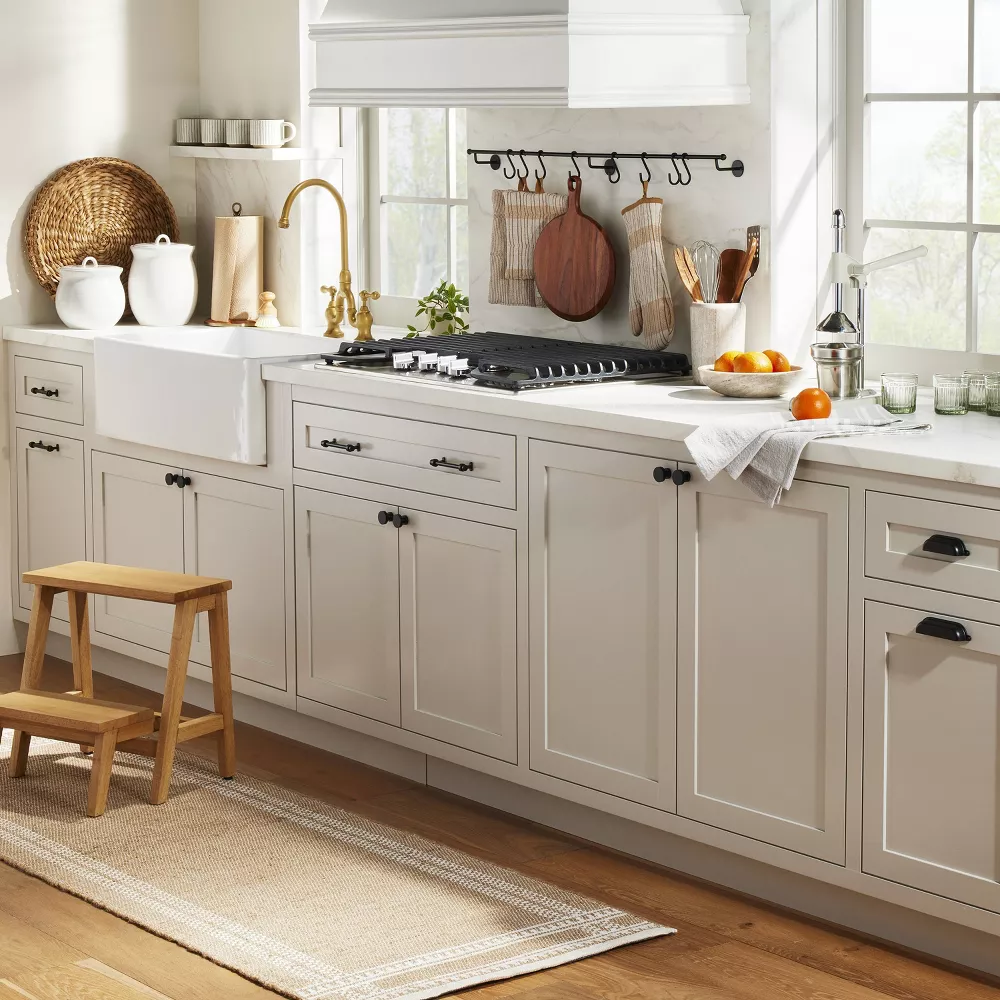 farmhouse kitchen with white cabinets, white countertops and black cabinet hardware
