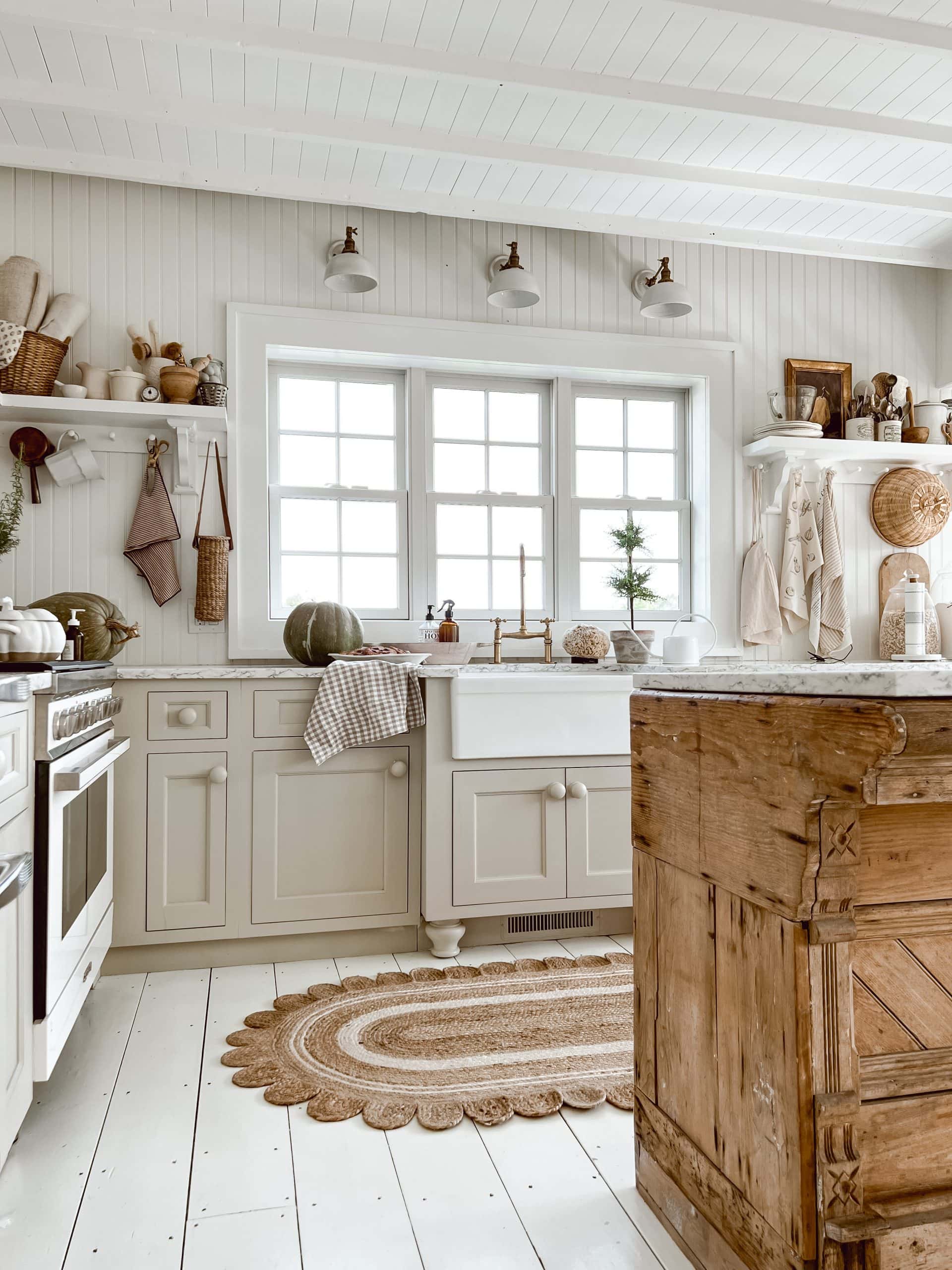rustic kitchen island paired with soft gray cabinets and marble countertops.