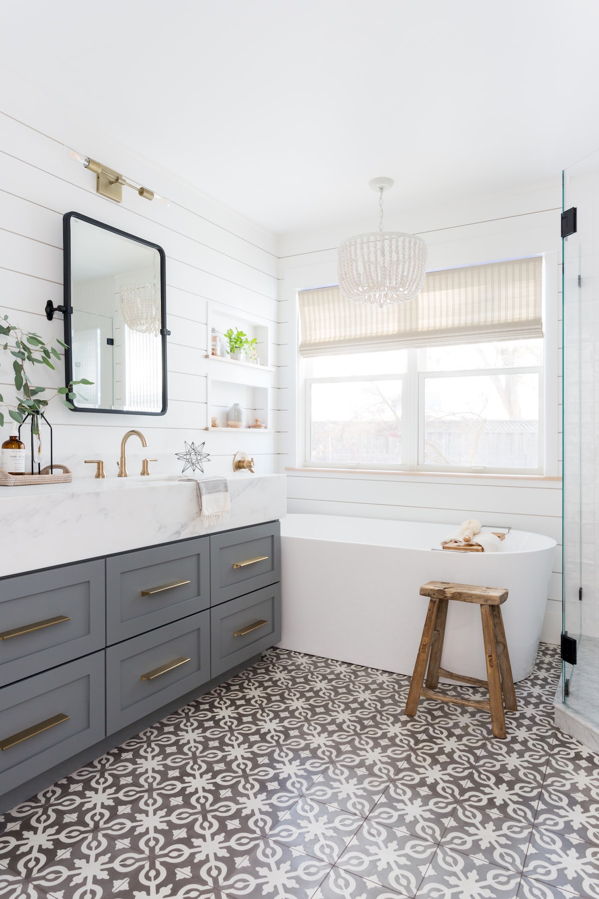 gray blue cabinet with white marble countertop and gold hardware in a modern farmhouse bathroom