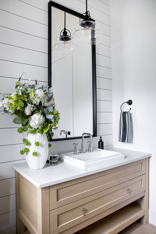 light gray shjplap walls with a wood vanity and raised white sink