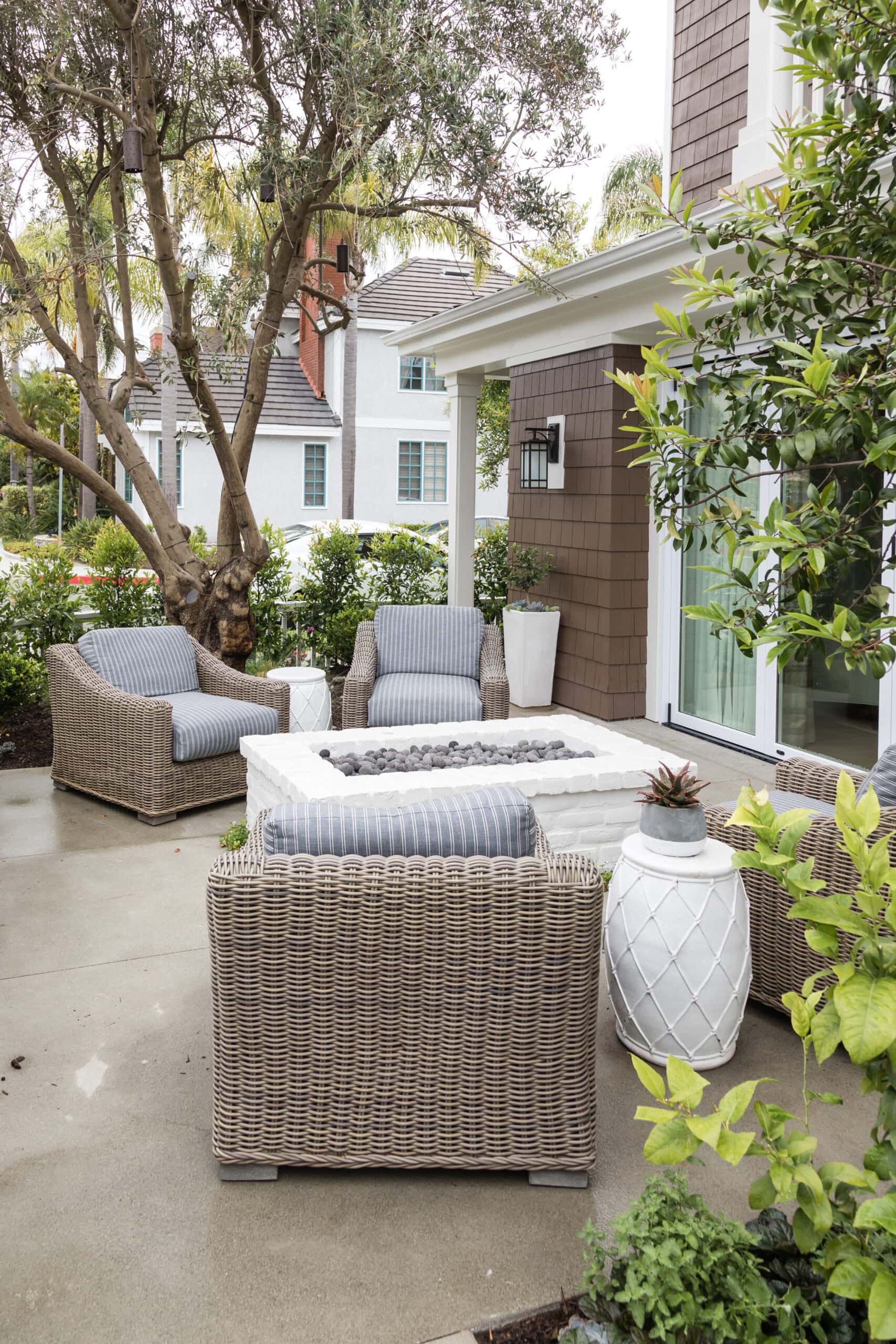 small patio space with rattan swivel chairs and potted plants