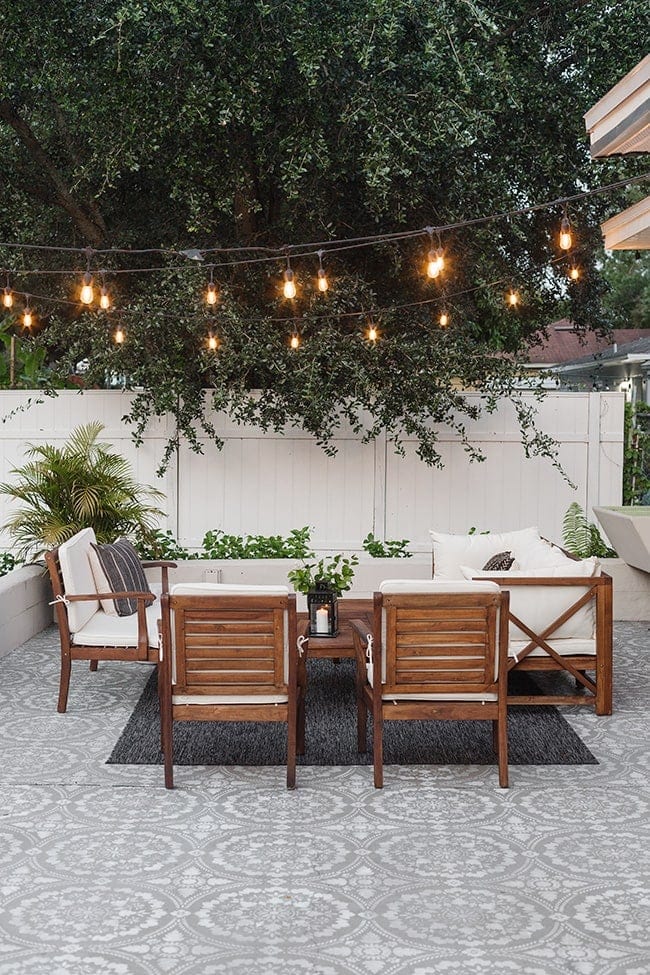 beautiful string of lights in trees above a patio seating area