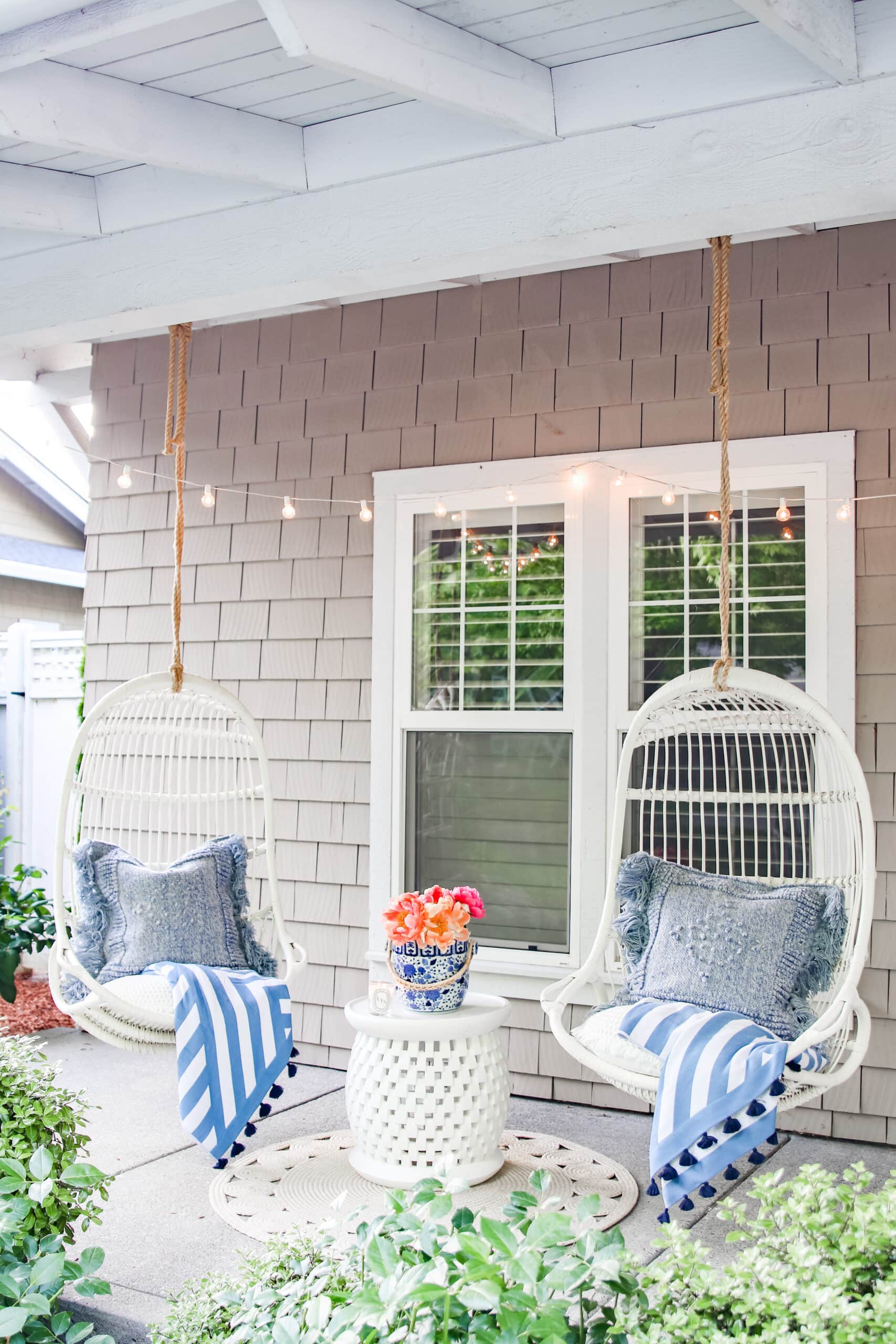 Brighten up your summer front porch with some colorful pillows and string lights. This will transform your outdoor space into a cozy retreat. It's the perfect setup for enjoying warm evenings with friends and family. #SummerDecor #PorchIdeas #OutdoorLiving