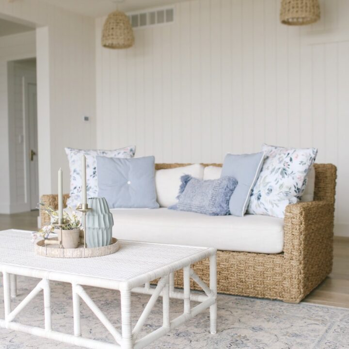 Image for Woven Rattan Couch Paired With Soft Blue Pillows & Light Fabrics